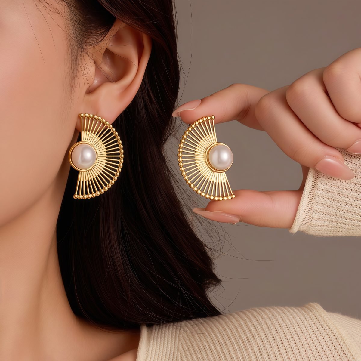 Woman wearing fan-shaped Cosmic Pearl Earrings with gold finish