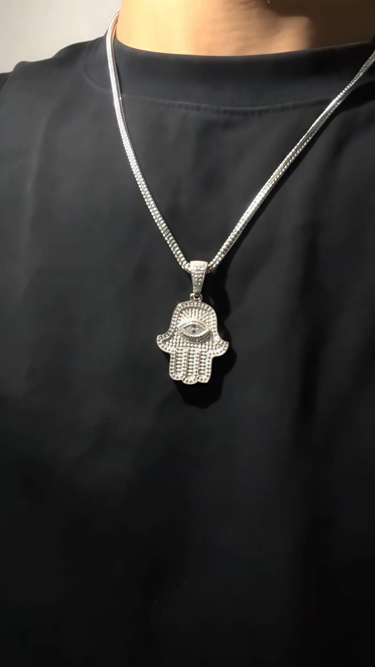 Model wearing Cosmic Harmony Hamsa Pendant layered with gold chains