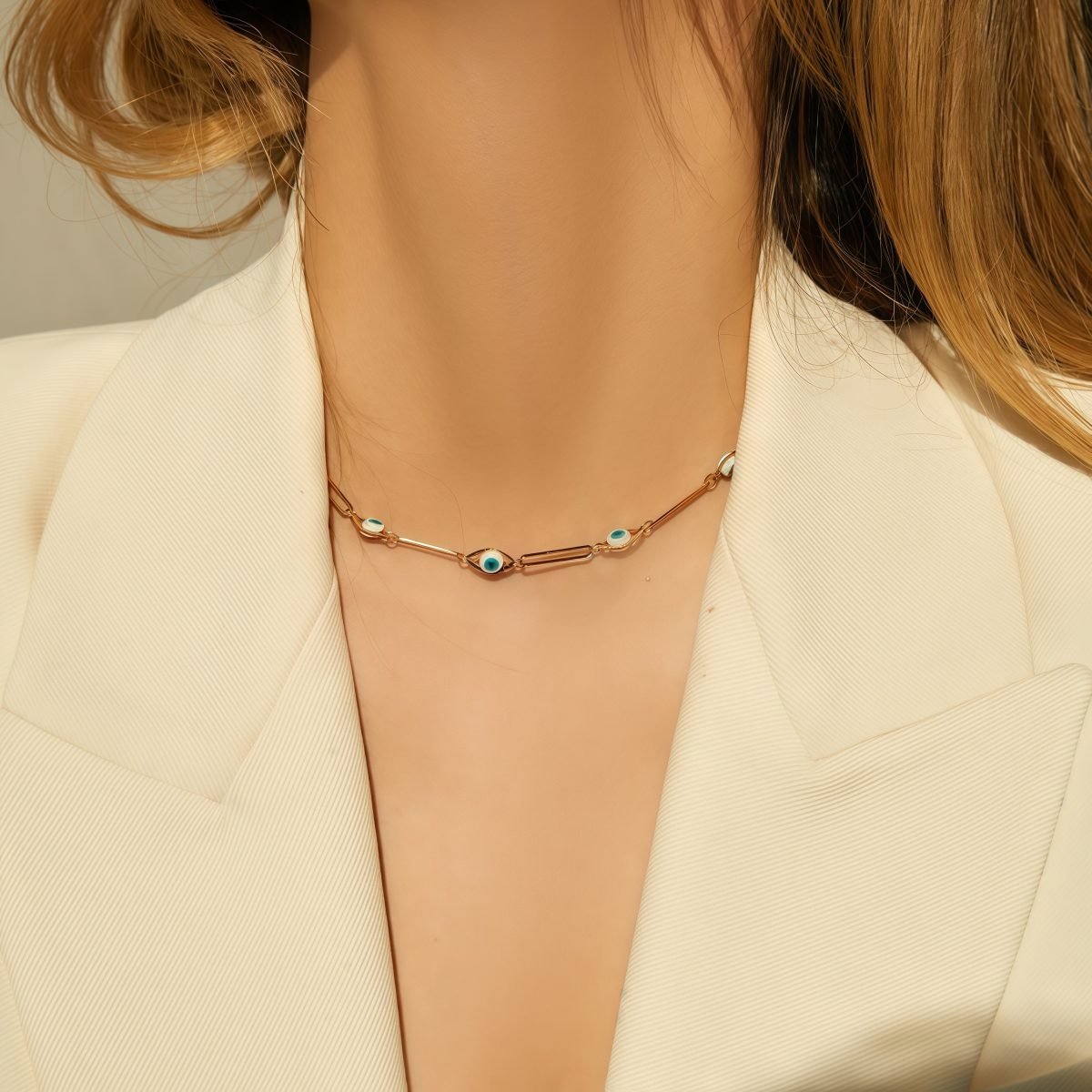 Model wearing gold cosmic energy evil eye necklace, front view close-up, soft lighting