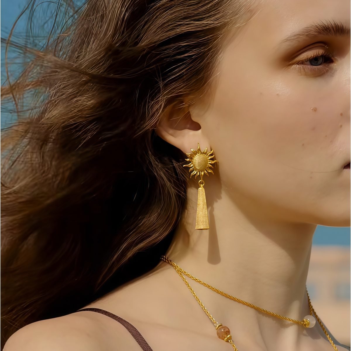 Model wearing cosmic energy-inspired sun earrings with radiant golden strands