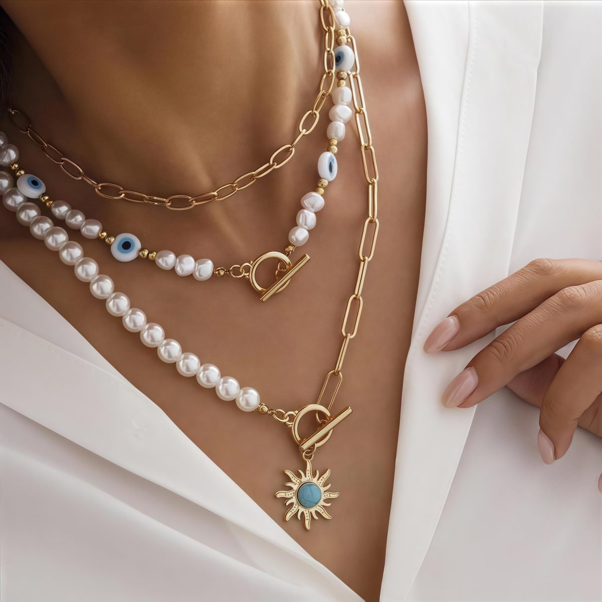 Close-up of model styling Cosmic Energy necklace set with pearls and sun charm