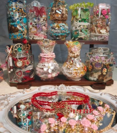 A pile of mysterious jewelry jars are placed on the shelf.